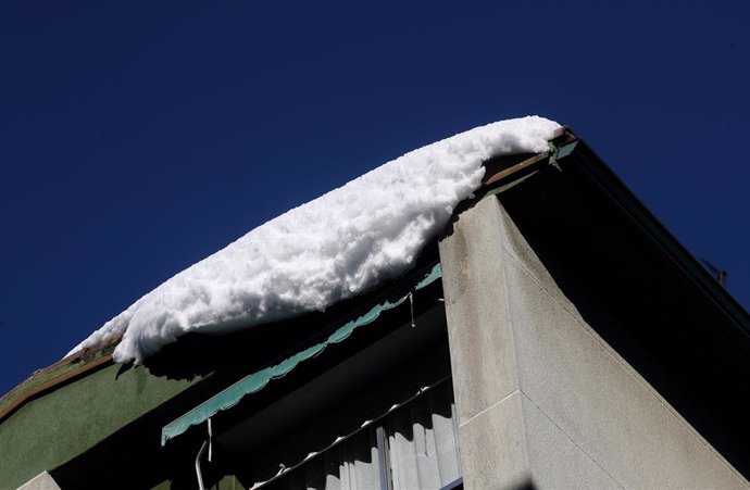 Un bloque de nieve helada cuelga en la cornisa de un edificio, en Madrid (España), a 13 de enero de 2021. Madrid sigue cubierto de nieve cinco días después de la gran nevada provocada por el paso de la borrasca Filomena. El Ayuntamiento hace balance d