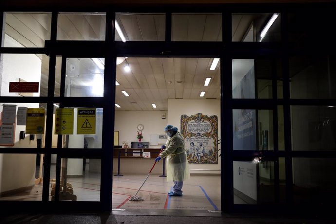 08 January 2021, Portugal, Lisbon: A cleaning worker wearing a protective suit cleans the floor at the Curry Cabral Hospital in Lisbon. Portugal reported a record 10,176 new Coronavirus (COVID-19) cases and 118 deaths in 24 hours, the highest daily figu