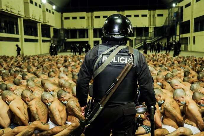 25 April 2020, El Salvador, Sonsonate: Apicture provided by El Salvador Presidency shows a police officers watching inmates wearing face masks during a police operation at the Centro Penal Izalco prison. Salvadoran President Nayib Bukele has ordered a 