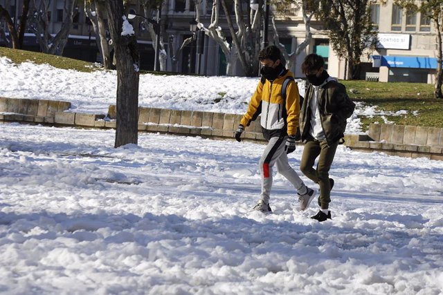 Transeúntes caminan por una vía con nieve durante una ola de frío en Albacete, Castilla-La Mancha (España), a 13 de enero de 2021. La ola de frío tras la gran nevada provocada por la borrasca ‘Filomena’ sigue dejando temperaturas "extremadamente frías" po