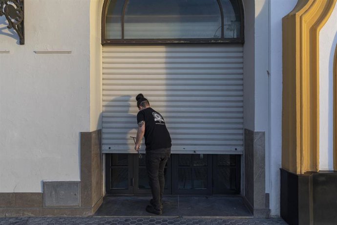 Un hostelero echa la persiana de su establecimiento