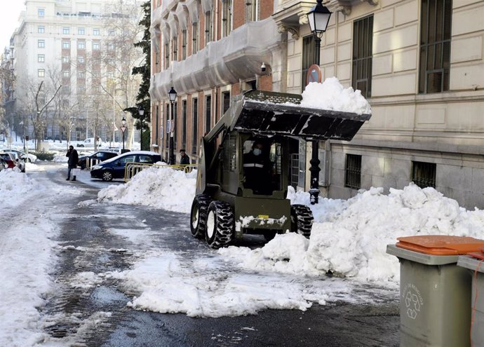 Una excavadora de la Unidad Militar de Emergencias (UME) durante la limpieza de la calle de Fortuny llena de nieve y con hielo tras el paso de la borrasca 'Filomena'