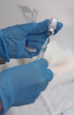 Un enfermero prepara una vacuna antes de inyectársela a un trabajador sanitario en las instalaciones del Hospital Enfermera Isabel Zendal, en Madrid, (España).