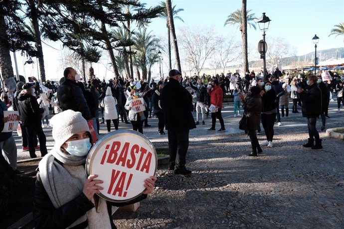 Una persona sostiene una objeto circular donde se puede leer '¡Basta ya!' en una manifestación convocada ante el Consolat de Mar el pasado martes. 