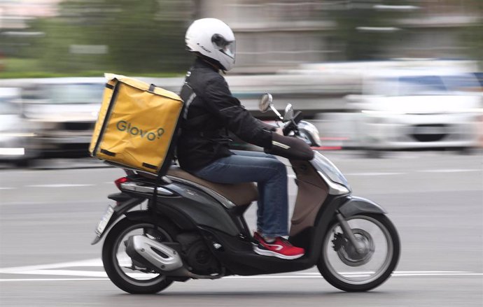Un repartidor de Glovo conduce una moto.