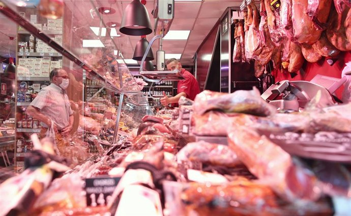 Un hombre trabaja en una carnicería el día en el que el INE ha publicado el Índice de Precios de Consumo (IPC)