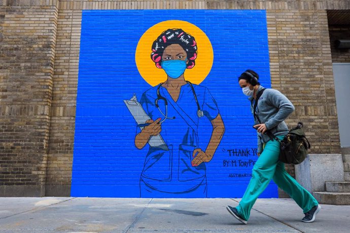 Un hombre pasa junto a un mural en Nueva York (EEUU) durante la pandemia de coronavirus