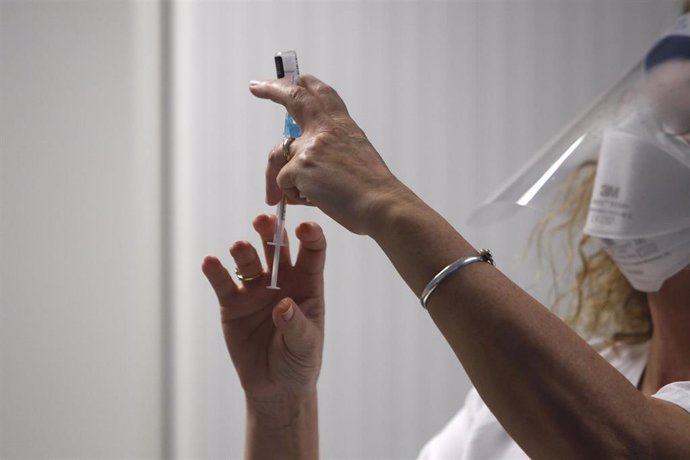 Una enfermera prepara la vacuna Pfizer-BioNtech contra el COVID-19 antes de administrársela a un profesional sanitario en el Hospital Son Espases de Palma de Mallorca, en Mallorca, Islas Baleares (España), a 13 de enero de 2021. Baleares ha arrancado es