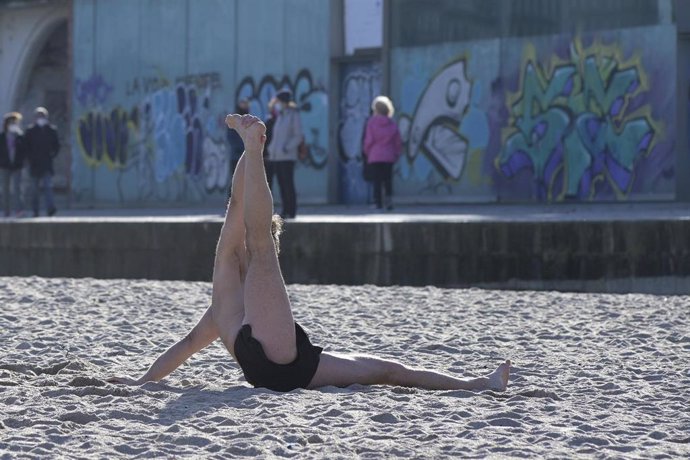 Un hombre hace estiramientos en una playa de A Coruña, Galicia (España), a 10 de enero de 2021.