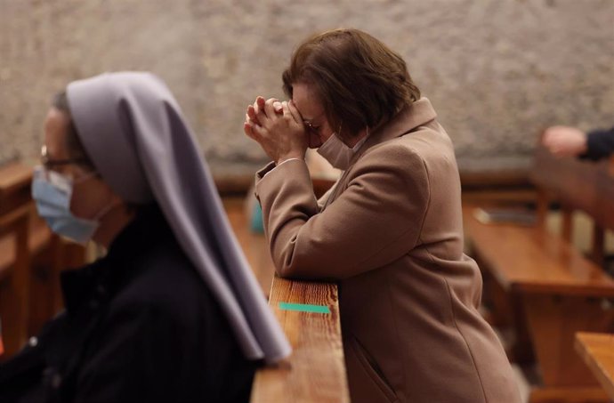 Una mujer reza durante una celebración en una parroquia.