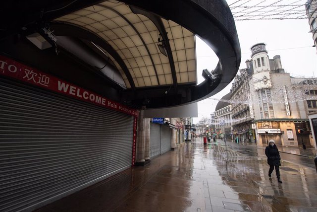 14 January 2021, England, London: A woman walks along a quiet street off Leicester Square in London during England's third national lockdown to curb the spread of coronavirus. Photo: Dominic Lipinski/PA Wire/dpa