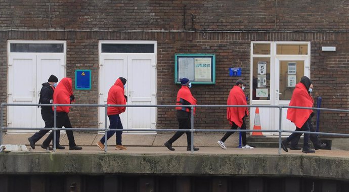 07 December 2020, England, Dover: A group of people thought to be migrants are brought in to Dover, Kent, by Border Force officers following a small boat incident in the English Channel. Photo: Gareth Fuller/PA Wire/dpa
