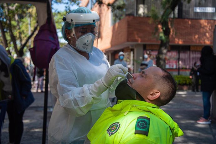 Un médico recolecta una muestra para realizar uan prueba para detectar el coronavirus a un operario municipal en Bogotá. 
