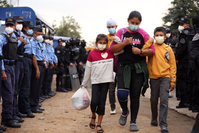 Una mujer y sus hijos atraviesan un punto de control de la Policía de Honduras en la andadura de la nueva caravana migrante que ya ha llegado a Guatemala.