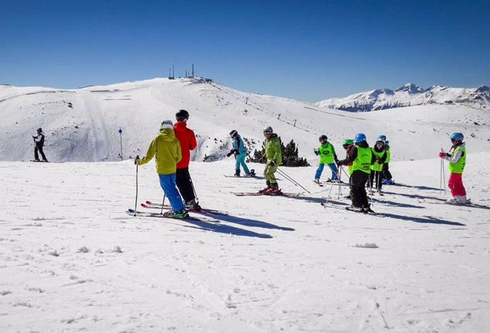 Grupo de niños aprendiendo a esquiar en la estación de Aramón Cerler