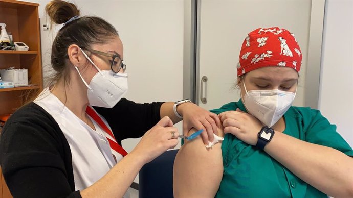 Una enfermera vacuna a una profesional sanitaria