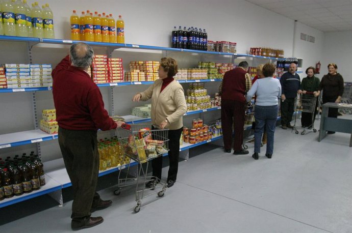 Voluntarios del economato social Casco Antiguo reponen productos en las estanterías