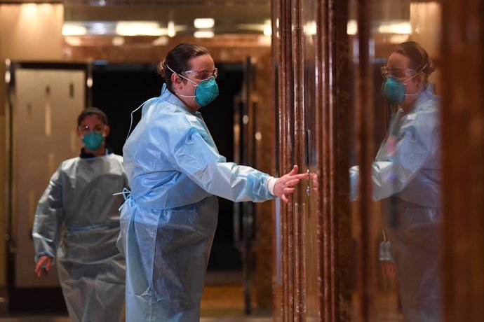 Health care workers wearing personal protective equipment are seen inside of the Grand Hyatt Melbourne in Melbourne, Tuesday, January 12, 2021. Three major hotels, the Grand Hyatt, Pullman Albert Park and the View on St Kilda Road in Melbourne have been