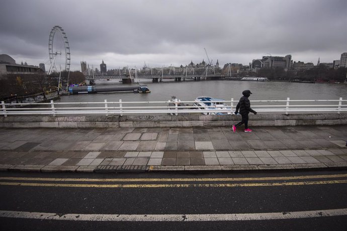 12 January 2021, England, London: A lone pedestrian walks over the empty Waterloo Bridge in central London during England's third national lockdown to curb the spread of coronavirus. Photo: Victoria Jones/PA Wire/dpa