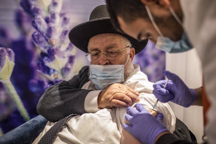 11 January 2021, Israel, Jerusalem: An Orthodox Jewish man receives his dose of the Pfizer-BioNTech COVID-19 vaccine at a vaccination centre as a part of a nationwide campaign. Israeli Health Minister Yuli Edelstein earlier said that Israel has vaccinat