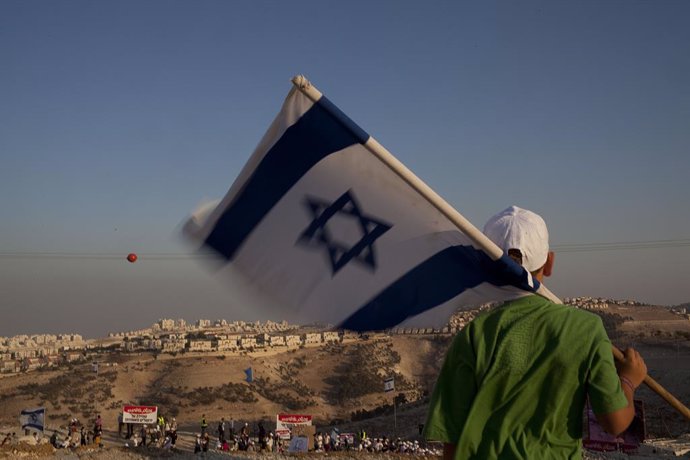Un colono con una bandera israelí en el asentamiento isarelí de Maale Adumim, en Cisjordania