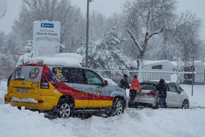 Una ambulancia ayuda a sacar un coche atrapado por la nieve durante la gran nevada provocada por la borrasca Filomena,  en Madrid (España), a 9 de enero de 2021. 