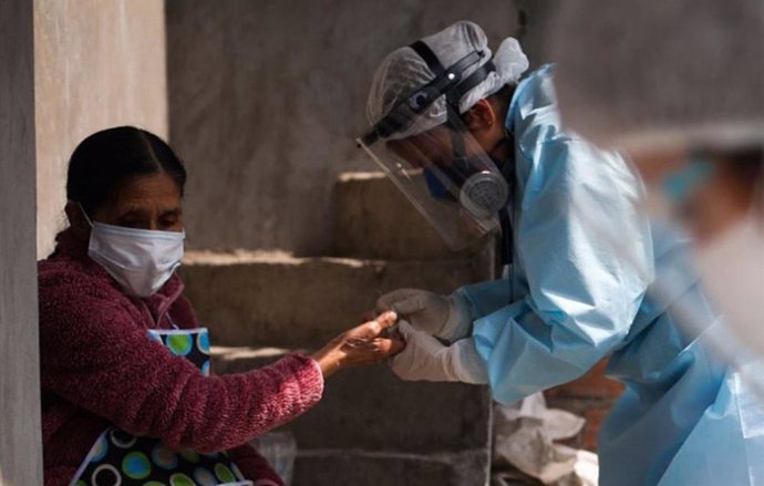 20 August 2020, Peru, Santa Anita: A health worker takes a blood sample from a woman for the coronavirus test during a door-to-door testing campaign. Photo: Jhonel Rodríguez Robles/Agentur Andina/dpa