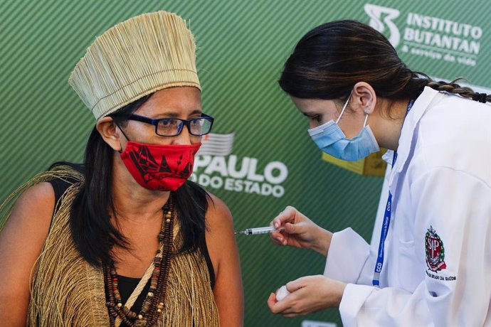 17 January 2021, Brazil, Sao Paulo: A woman receives his dose of the Coronavirus (Covid-19) vaccine by a health worker during a vaccination campaign. Brazil's National Health Surveillance Agency has granted emergency approval to each of Sinovac's and As