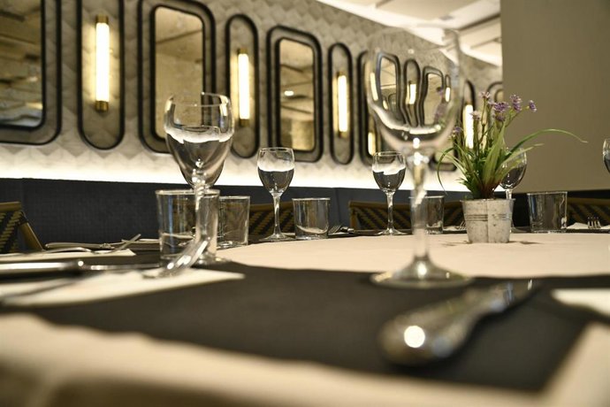 Mesa con matel blanco y tapete negro.