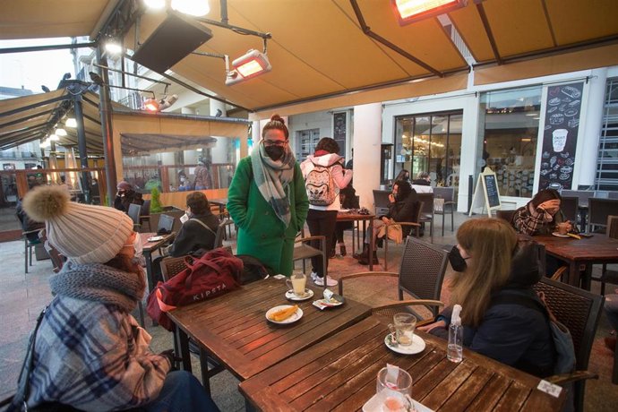 Tres chicas en la terraza de un restaurante el primer día del cierre perimetral decretado en Lugo, Galicia (España), a 15 de enero de 2021. El cierre perimetral forma parte del paquete de nuevas restricciones de la Xunta para frenar la expansión del vir