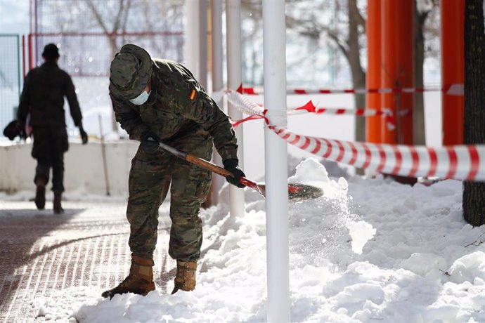 Un militar de la Unidad Militar de Emergencias (UME) colabora en la retirada de nieve y hielo en las inmediaciones del colegio Fuente de la Villa, en Valdemoro (Madrid)