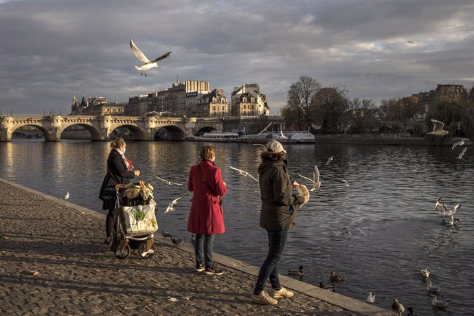 Mujeres con mascarilla junto al río Sena en París, Francia
