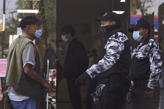 18 March 2020, Mexico, Mexico City: Police officers stop a man wearing a face mask to prevent the spread of Coronavirus (Covid-19), in the vicinity of the National Institute of Respiratory Diseases. Photo: Paola Hidalgo/NOTIMEX/dpa
