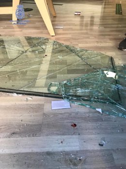 Imagen de los cristales rotos de la entrada del establecimiento donde se produjo el robo.