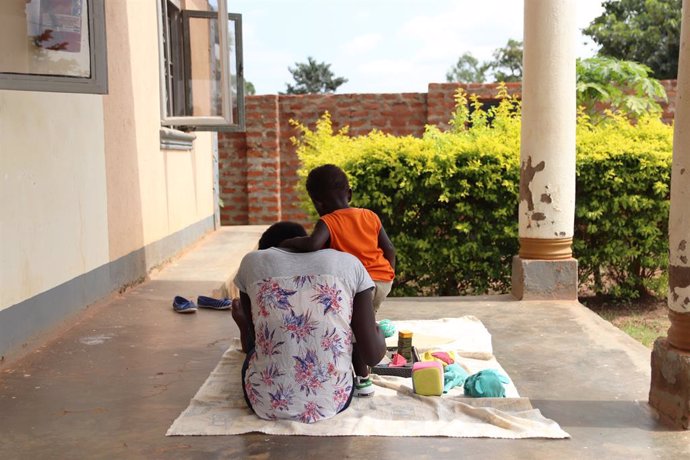 Mercy de 17 años juega con su hija de dos años en un centro de Plan International