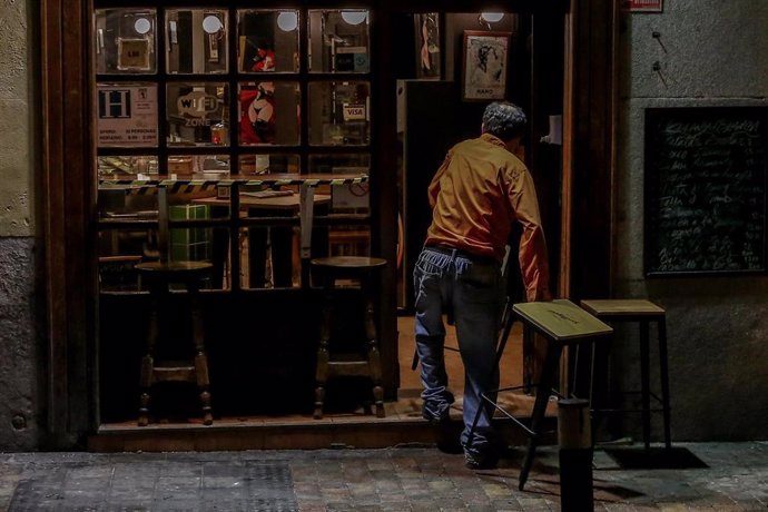 Un hombre cierra su restaurante el día en el que se adelanta el cierre de hostelería a las 22.00h, en Madrid (España), a 18 de enero de 2021. La Comunidad de Madrid amplió las restricciones el pasado viernes, 15 de enero tras el aumento de casos de coro