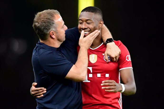 Hansi Flick realiza un gesto cariñoso a Alaba durante un partido del Bayern