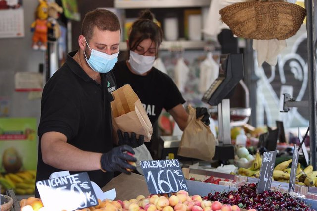 Dos trabajadores de una frutería del Mercado Central de Valencia