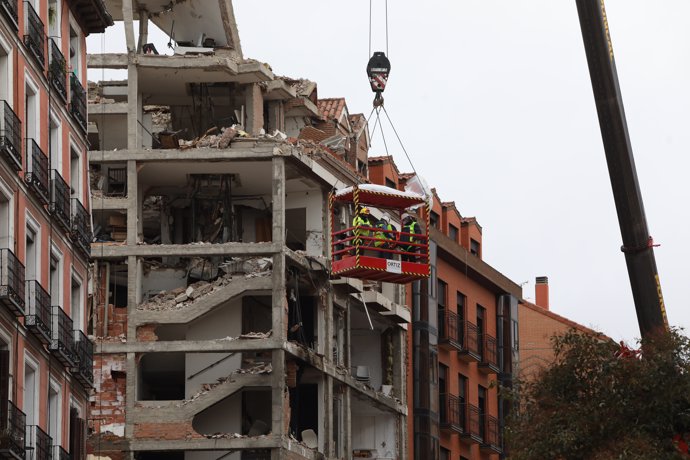 Varios operarios colgados de una grúa trabajan en la inspección ocular del edificio tras la explosión de ayer en la calle Toledo