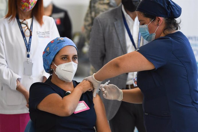 18 January 2021, Chile, Antofagasta: A nurse receives a Pfizer-Biontech Coronavirus vaccine dose during the vaccination campaign for the medical staff. Photo: Camilo Alfaro/Agencia Uno/dpa