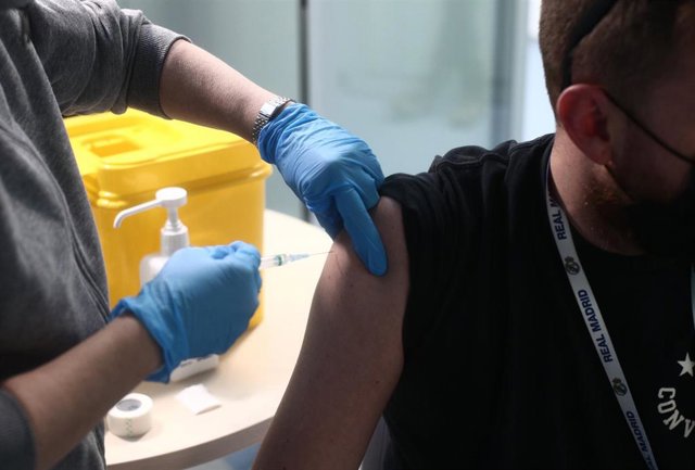 Un enfermero vacuna a un trabajador sanitario en las instalaciones del Hospital Enfermera Isabel Zendal, en Madrid, (España), a 12 de enero de 2021. Hoy es el tercer día que se están administrando vacunas en este hospital después de que la gran nevada cau