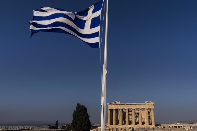 Una bandera de Grecia frente al Partenón, en Atenas