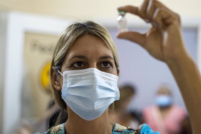 Una trabajadora sanitaria sostiene una dosis de la vacuna rusa Sputnik V en Argentina.