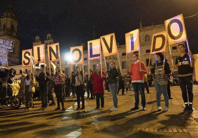 18 March 2019, Colombia, Bogota: People hold placards as they take part in a demonstration in favour of the country's peace process with the former FARC guerrillas and against the policies of the Colombian President Ivan Duque.  The protests were prompt