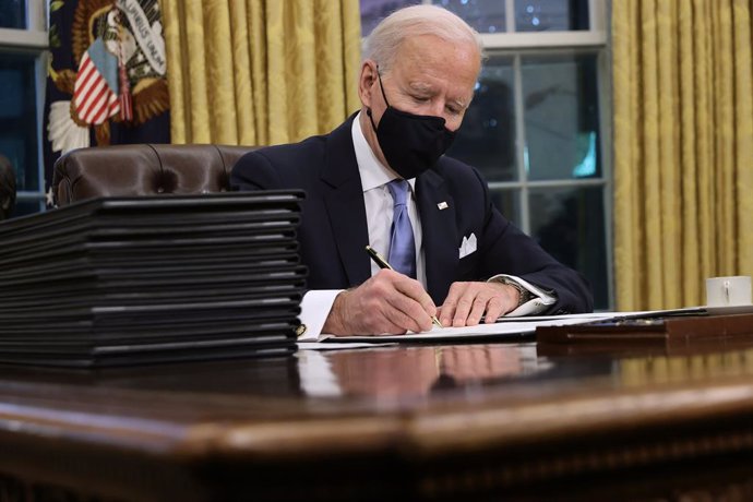 El presidente de Estados Unidos, Joe Biden, firma sus primeros decretos en el Despacho Oval.