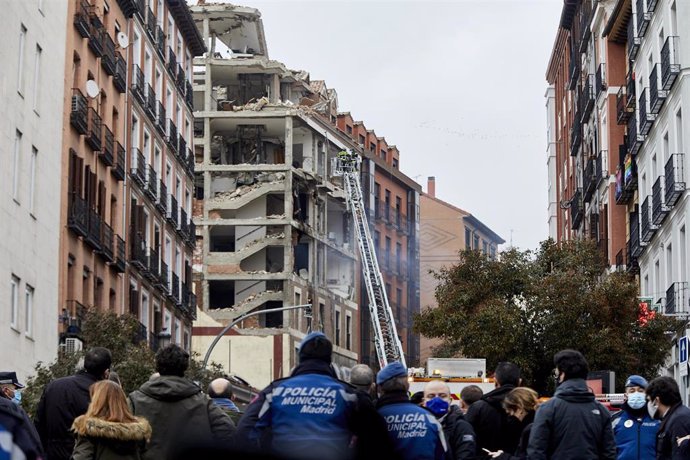 Dos bomberos trabajan en un inmueble momentos posteriores a una fuerte explosión registrada la calle Toledo que ha hundido varias plantas del edificio, en Madrid, (España).