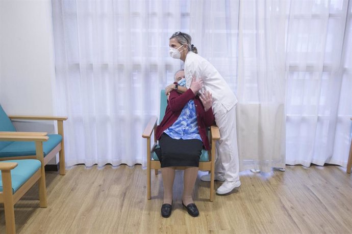 Una enfermera abraza a Eulalia Josefa `Pepita Paleo, primera usuaria de la residencia en recibir la segunda dosis de la vacuna Pfizer-BioNTech en el Centro Polivalente de Recursos Residencia Mixta de Gijón.