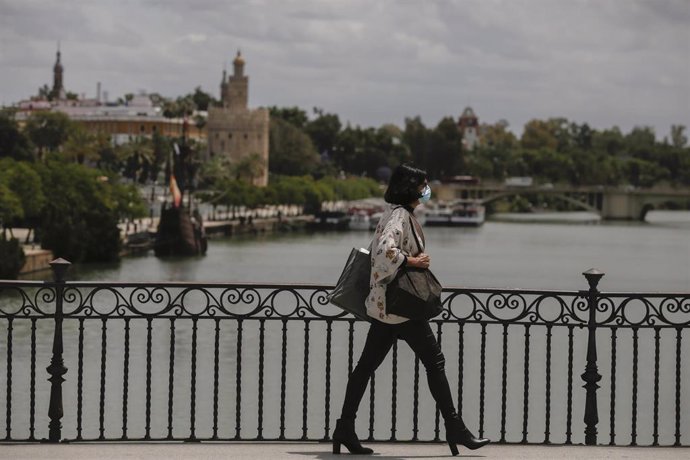 Una mujer caminando por el puente de Triana 