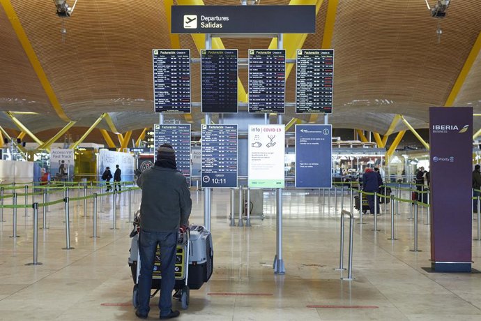 Un pasajero observa los paneles indicativos de la situación de los vuelos donde se pueden observar varios trayectos cancelados en la terminal 4 del aeropuerto Madrid-Barajas