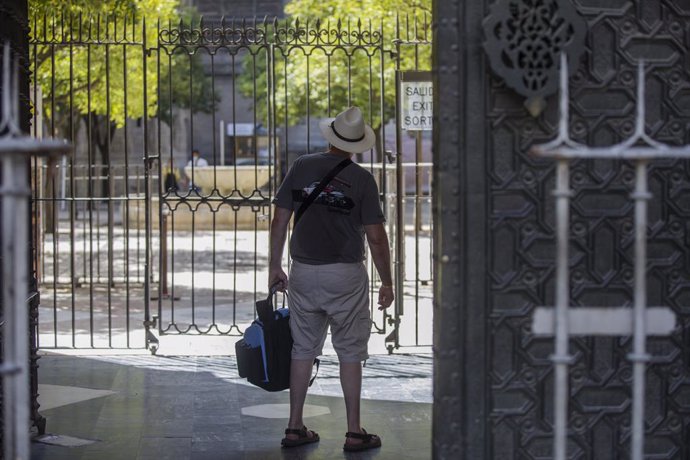 Un turista observa el Patio de los Naranjos desde la salida de la Catedral de Sevilla.